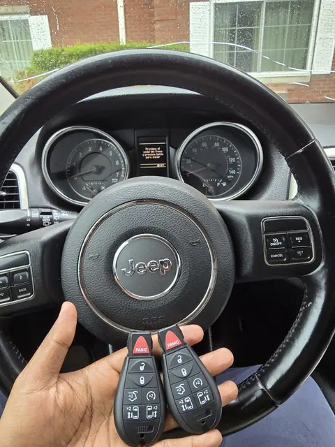 Two new remote keys in front of a Jeep steering wheel