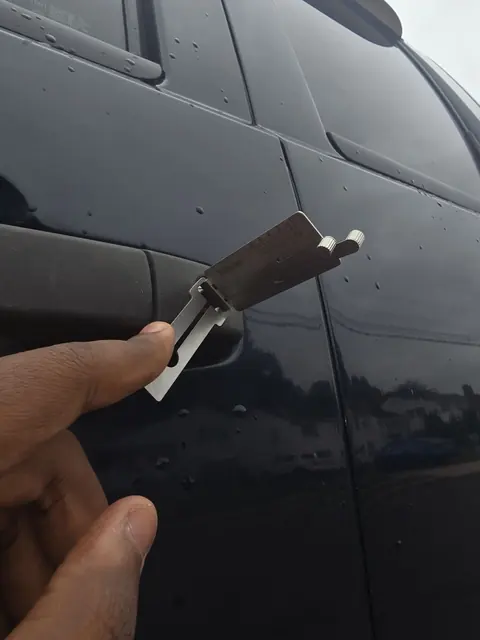 Pick tool in the door lock of a dark car