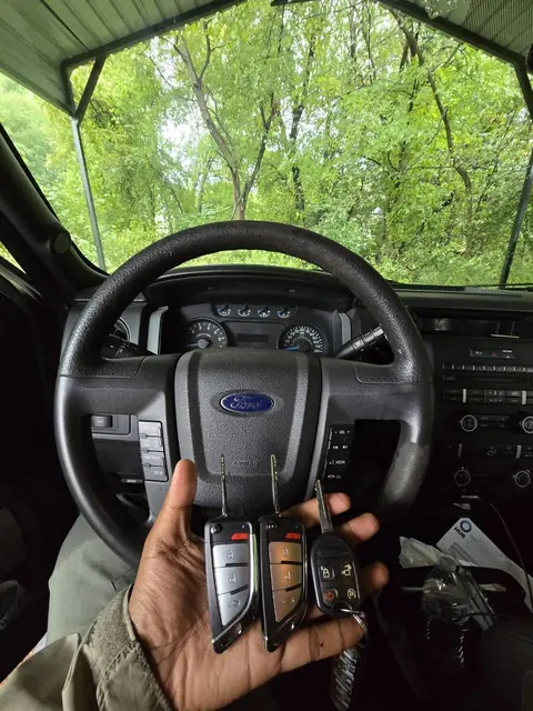 Three new remote keys in front of a Ford F-150 steering wheel